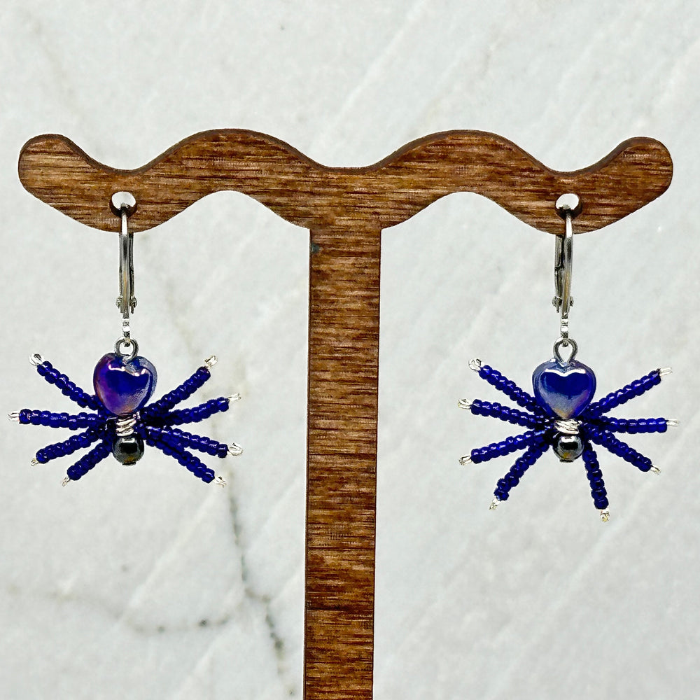 Pair of dark blue Spider Beaded Earrings with Stainless Steel Lever Backs, handmade in Montana USA by Aurum Shimmer, on card