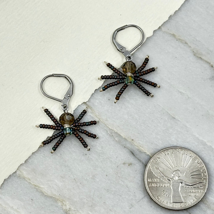 Pair of grey Spider Beaded Earrings with Stainless Steel Lever Backs, handmade in Montana USA by Aurum Shimmer, with scale