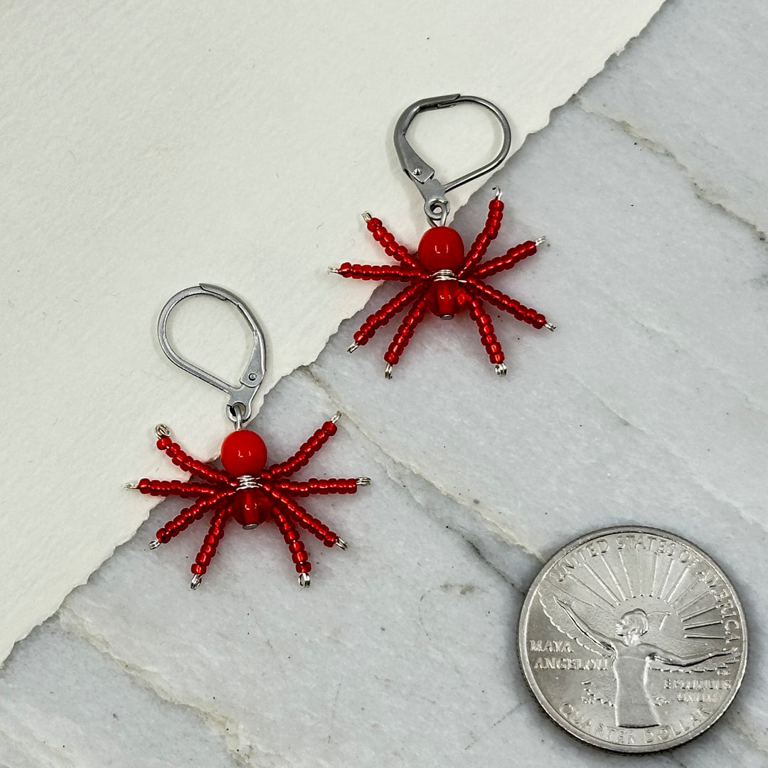 Pair of red Spider Beaded Earrings with Stainless Steel Lever Backs, handmade in Montana USA by Aurum Shimmer, with scale
