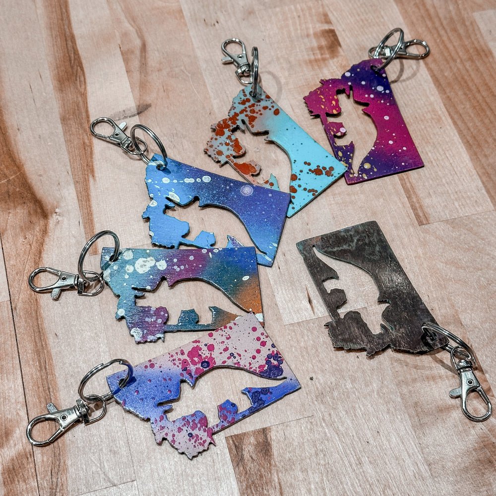 This made in Montana Triceratops Metal Keychain showcases a state-shaped design with a triceratops cut out of it.