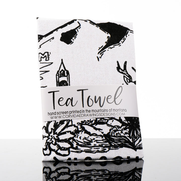 This made in Montana printed tea towel by Corvidae features a black and white drawing of Mount Sentinel, the M, the clock tower, bitterroots and a deer in Missoula Valley.