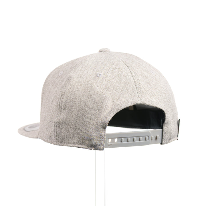 The back of a heather grey flexfit flat bill hat with a hexagon elk silhouette flexwood patch.