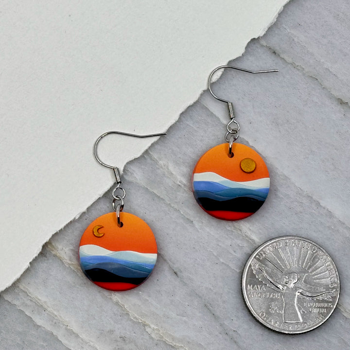 Pair of La Petite Rose's Big Sky Montana Sun Moon Landscape Clay Earrings (orange), with scale