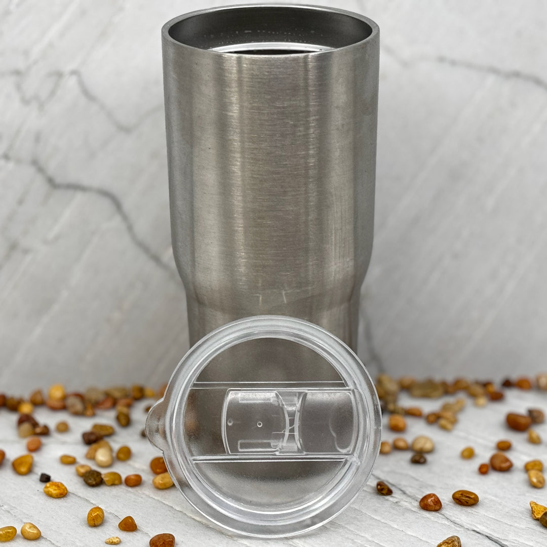 Blue Peak Creative's Silver 22oz Stainless Steel Tumbler decorated with the Montana Grizzlies Charging Bear design in black (top off)