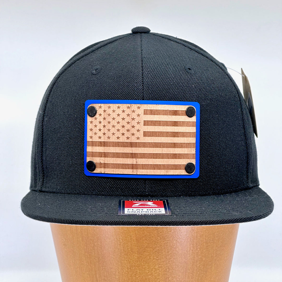 American Flag Wood & Blue Anodized Aluminum Plate Richardson Flat Bill Hat featuring an American Flag etched on alder wood veneer and laminated to a blue anodized aluminum plate—handmade in Montana, USA by Last Best Supply Co.