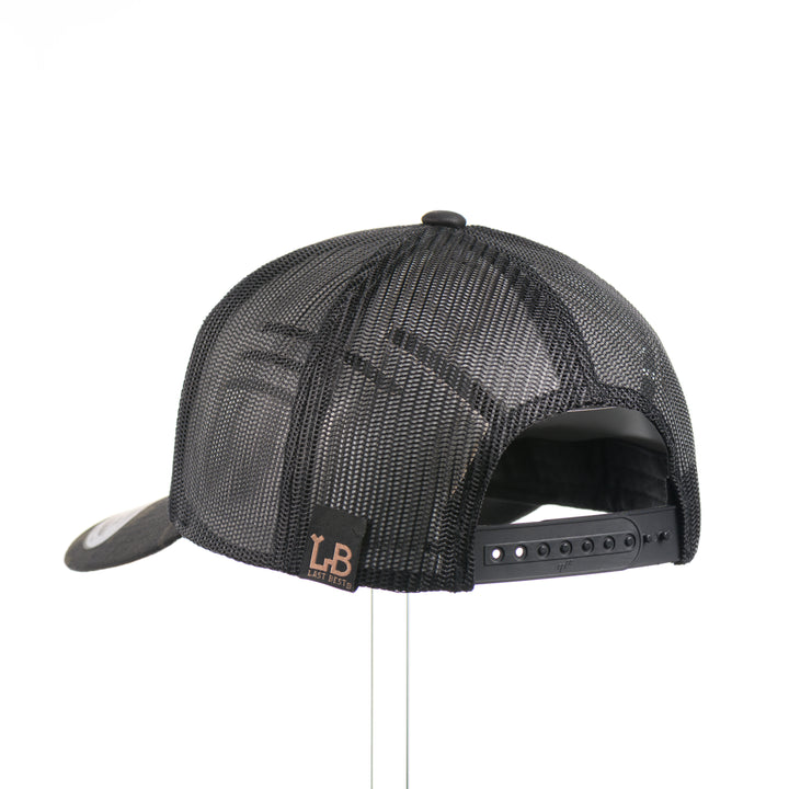 The back of a dark multicam trucker hat with a flexwood steer skull patch, handmade in Montana USA by Last Best Supply Co.