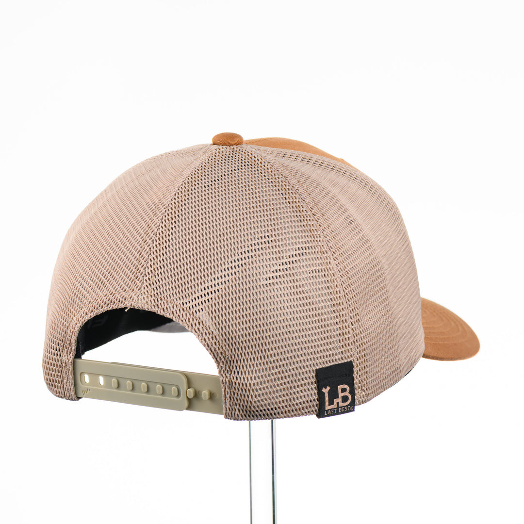 Etched Leather Bull Skull Patch Flexfit Trucker Hat, featuring a real leather patch cut into the shape of a steer skull and etched with detail, securely attached to a caramel and khaki trucker hat—handmade in Montana, USA by Last Best Supply Co.