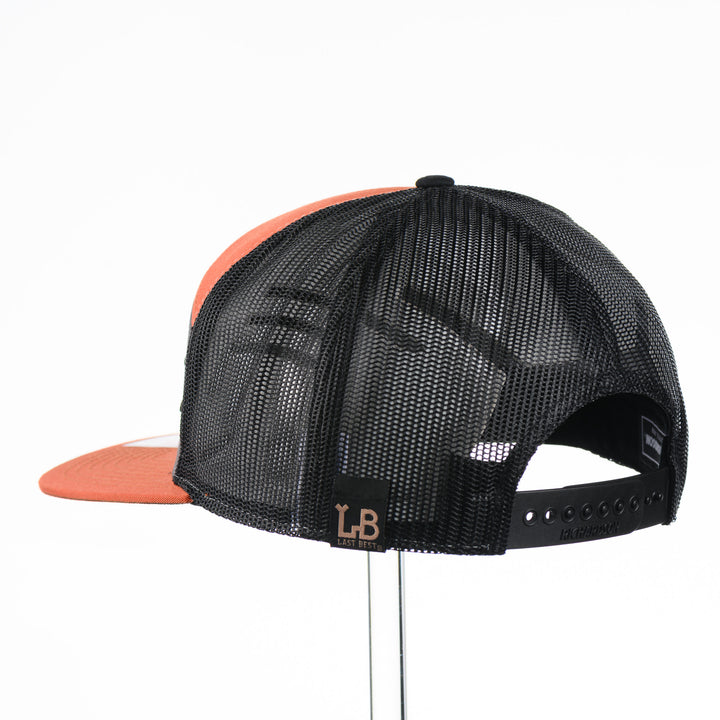 Etched Leather Chinook Salmon Patch Flat Bill Trucker Hat, featuring a real leather patch cut into the shape of a Chinook Salmon and etched with detail, securely attached to an orange and grey trucker hat—handmade in Montana, USA by Last Best Supply Co.