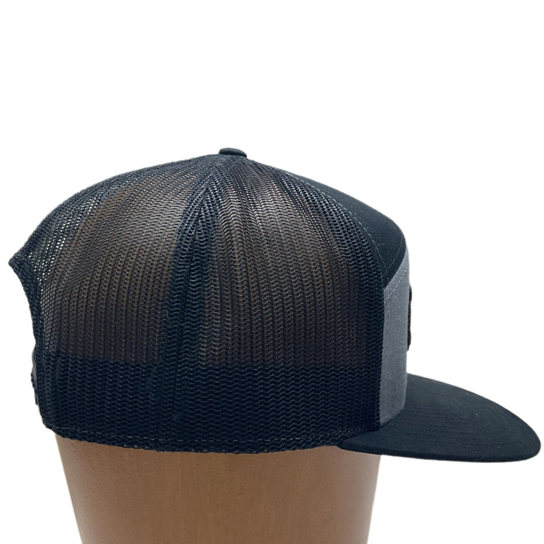 Side of a Hex Bear MT Wood Patch Richardson Flat Bill Hat, featuring a hexagonal, real wood veneer patch etched with a grizzly bear and the letters “MT”, laminated to a black anodized metal plate, and then riveted to heather gray and black Richardson 168 seven-panel flat bill trucker hat—handmade in Montana, USA by Last Best Supply Co.