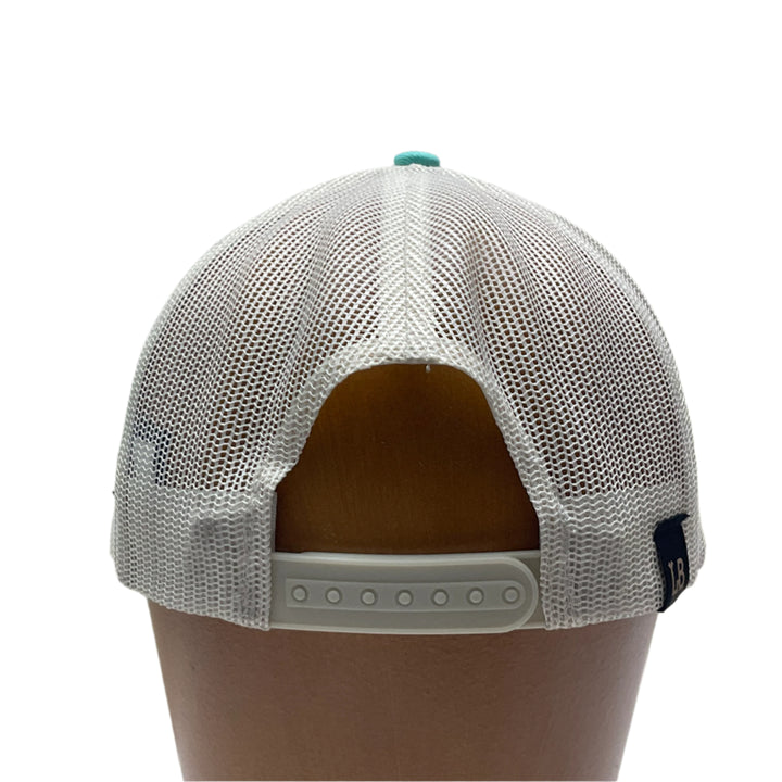 Back view of a Premium Leather Montana Bear on Low Profile Teal Trucker Hat, featuring a blue hand-dyed leather patch cut in the shape of the state of Montana with a grizzly bear cut-out, heat pressed to the structured front of a teal and white  trucker hat—handmade in Montana, USA by Last Best Supply Co.