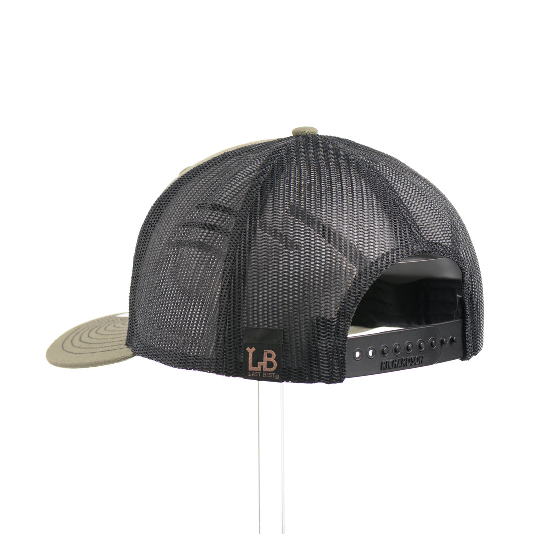 The back of a loden green and black mesh Richardson trucker hat with an etched walnut wood American flag and bison cut out on a black metal patch—handmade in Montana, USA by Last Best Supply Co.