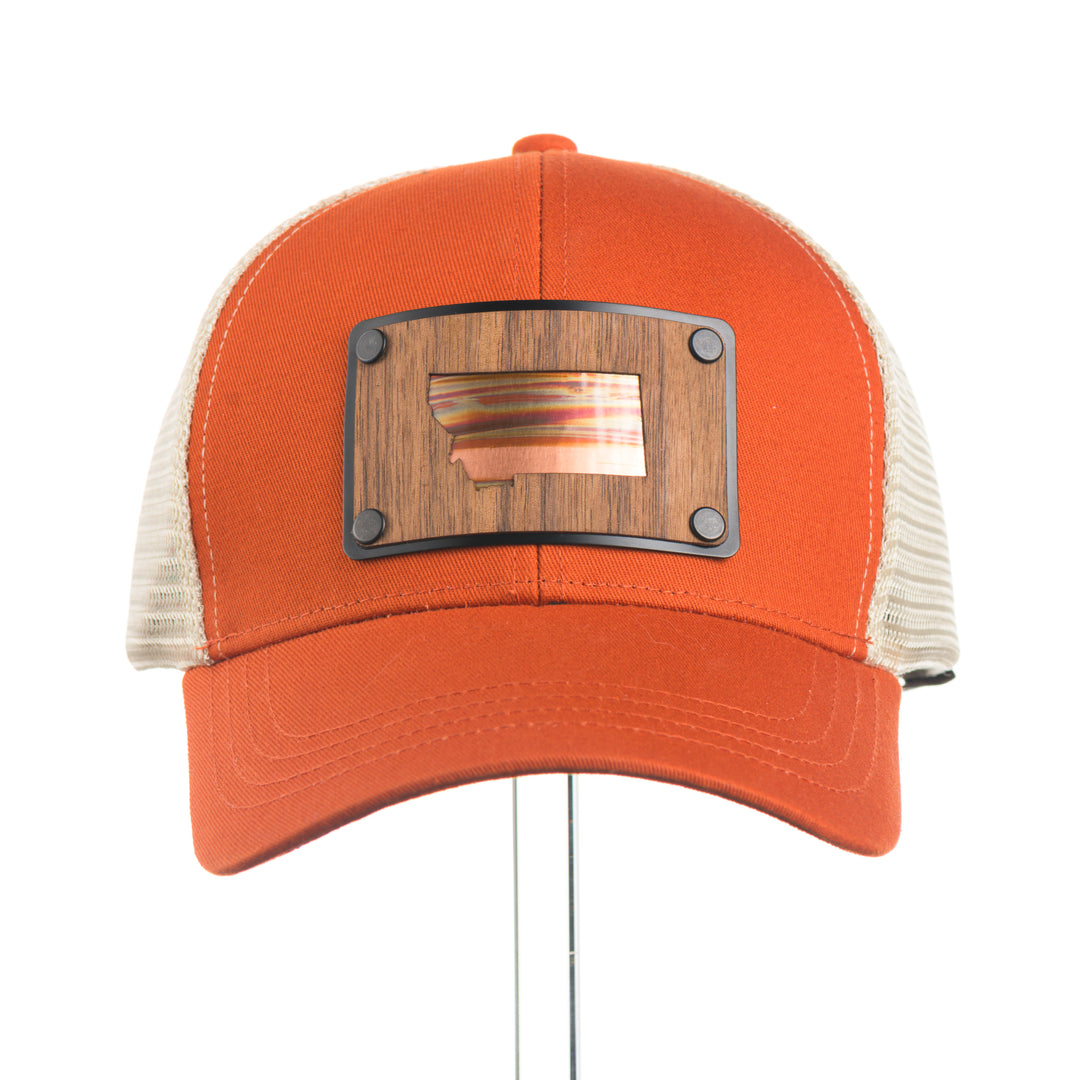 Orange trucker cap with wood and copper Montana patch on a white background