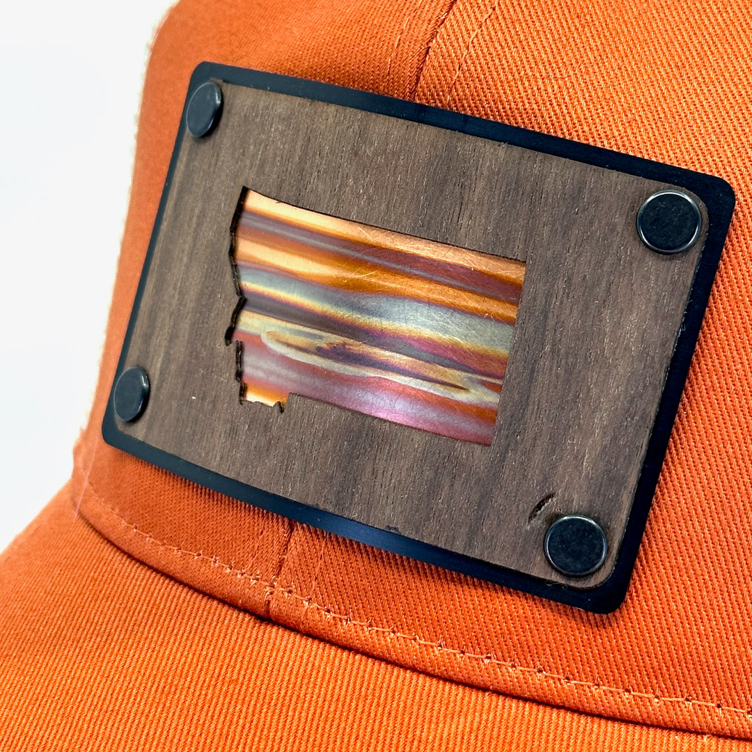 A close up of a walnut wood and copper Montana patch hat