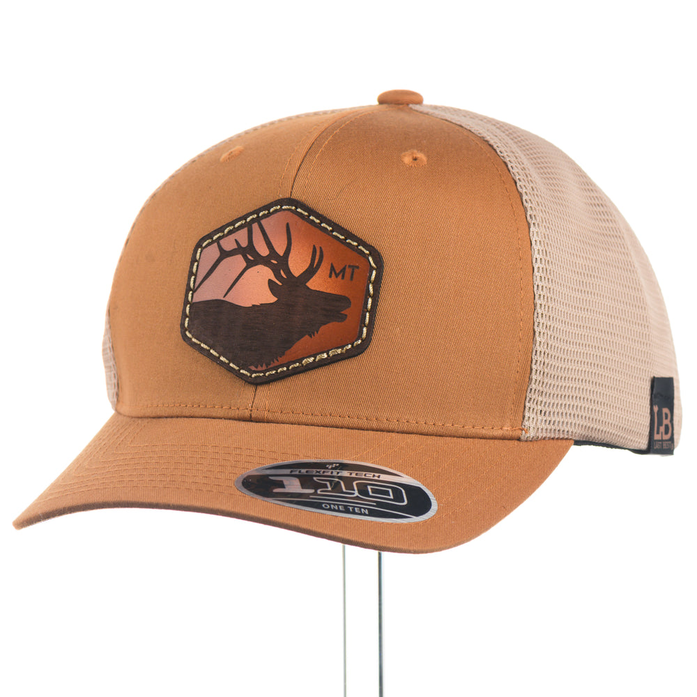 Brown  flexfit trucker cap with mesh back and elk leather patch on a white background