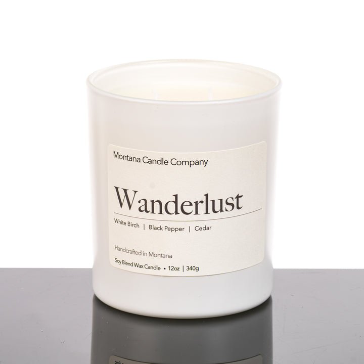 Wanderlust Candle soy blend candle handmade in Missoula, Montana by Montana Candle Company, scented with a white birch, black pepper, and cedar, 12 oz. glass tumbler