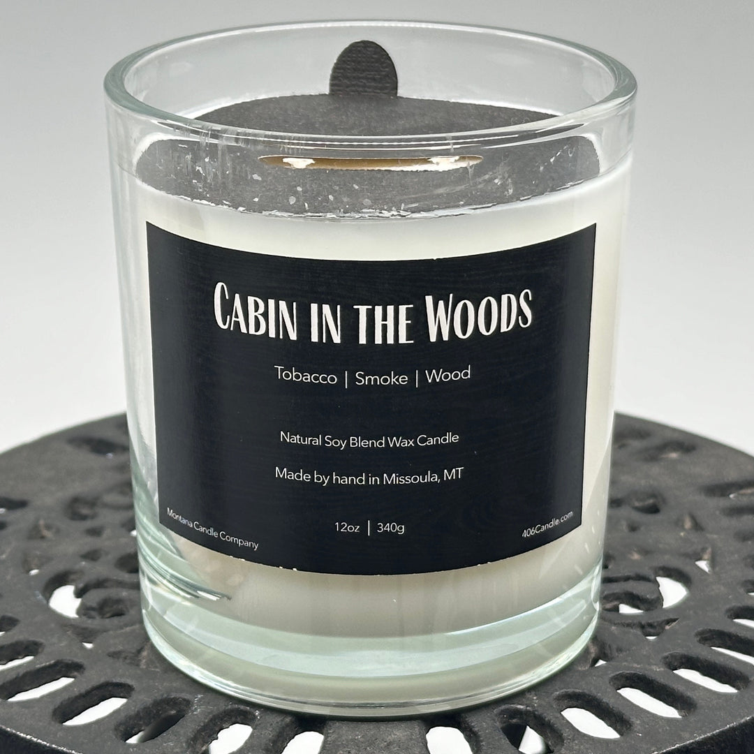 Cabin in the Woods Candle handmade in Missoula, Montana by Montana Candle Company, with a blend of tobacco, smoke, and wood scents, in a 12 oz. glass tumbler