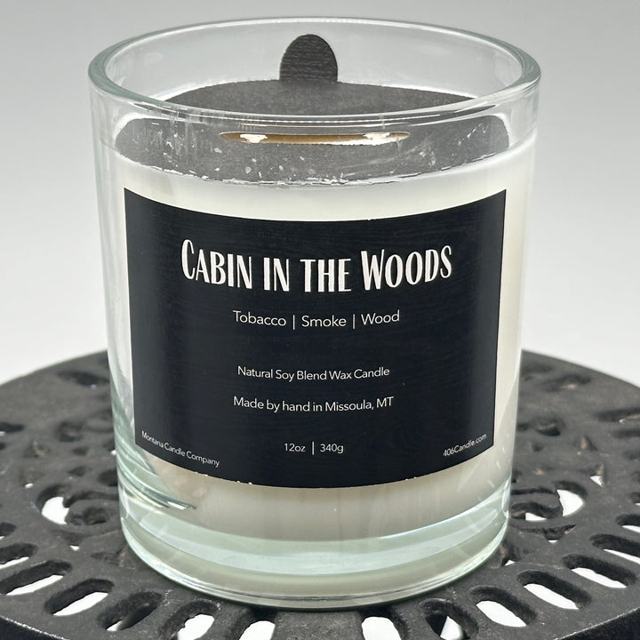 Cabin in the Woods Candle handmade in Missoula, Montana by Montana Candle Company, with a blend of tobacco, smoke, and wood scents, in a 12 oz. glass tumbler