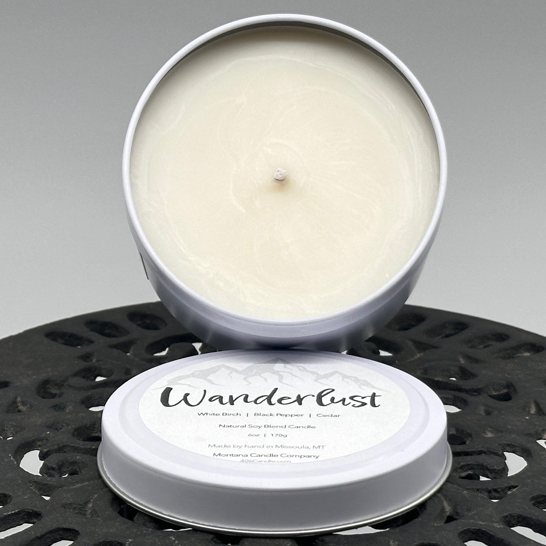 Wanderlust Candle soy blend candle handmade in Missoula, Montana by Montana Candle Company, scented with a white birch, black pepper, and cedar, 6 oz. tin