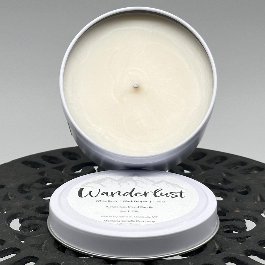 Wanderlust Candle soy blend candle handmade in Missoula, Montana by Montana Candle Company, scented with a white birch, black pepper, and cedar, 6 oz. tin