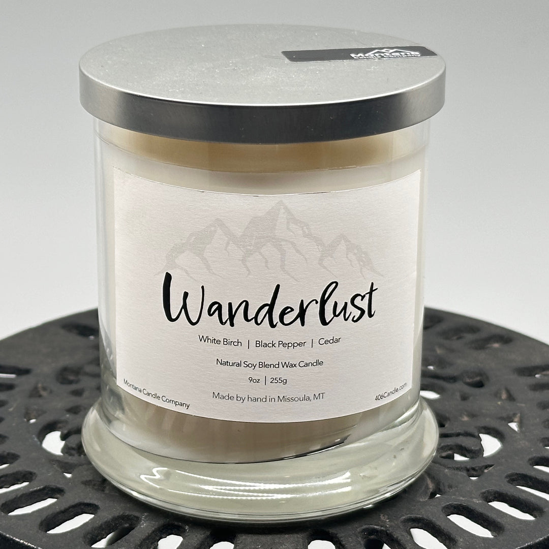 Wanderlust Candle soy blend candle handmade in Missoula, Montana by Montana Candle Company, scented with a white birch, black pepper, and cedar, 9 oz. glass tumbler
