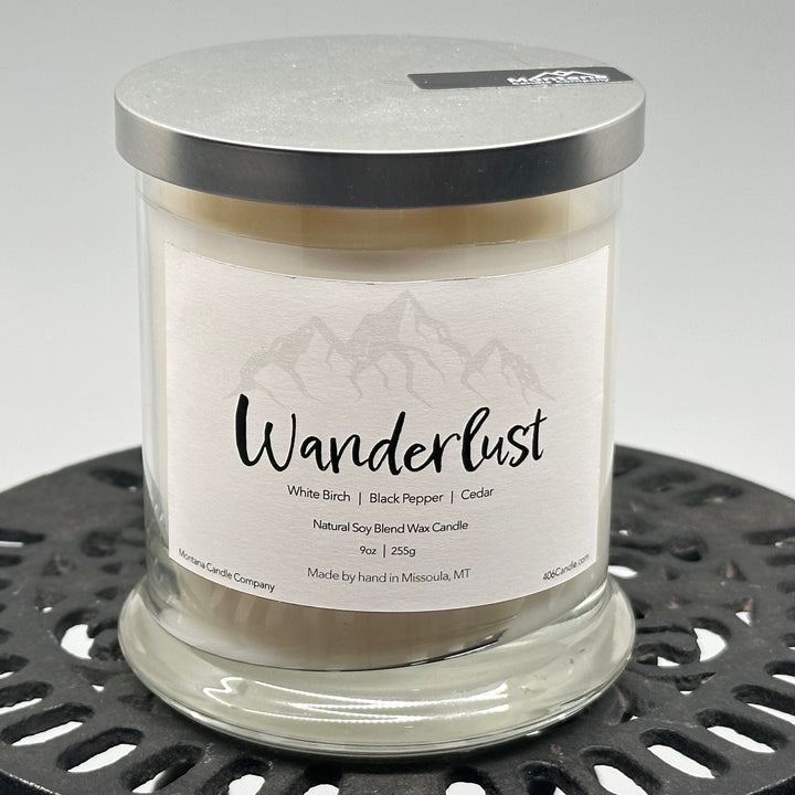 Wanderlust Candle soy blend candle handmade in Missoula, Montana by Montana Candle Company, scented with a white birch, black pepper, and cedar, 9 oz. glass tumbler