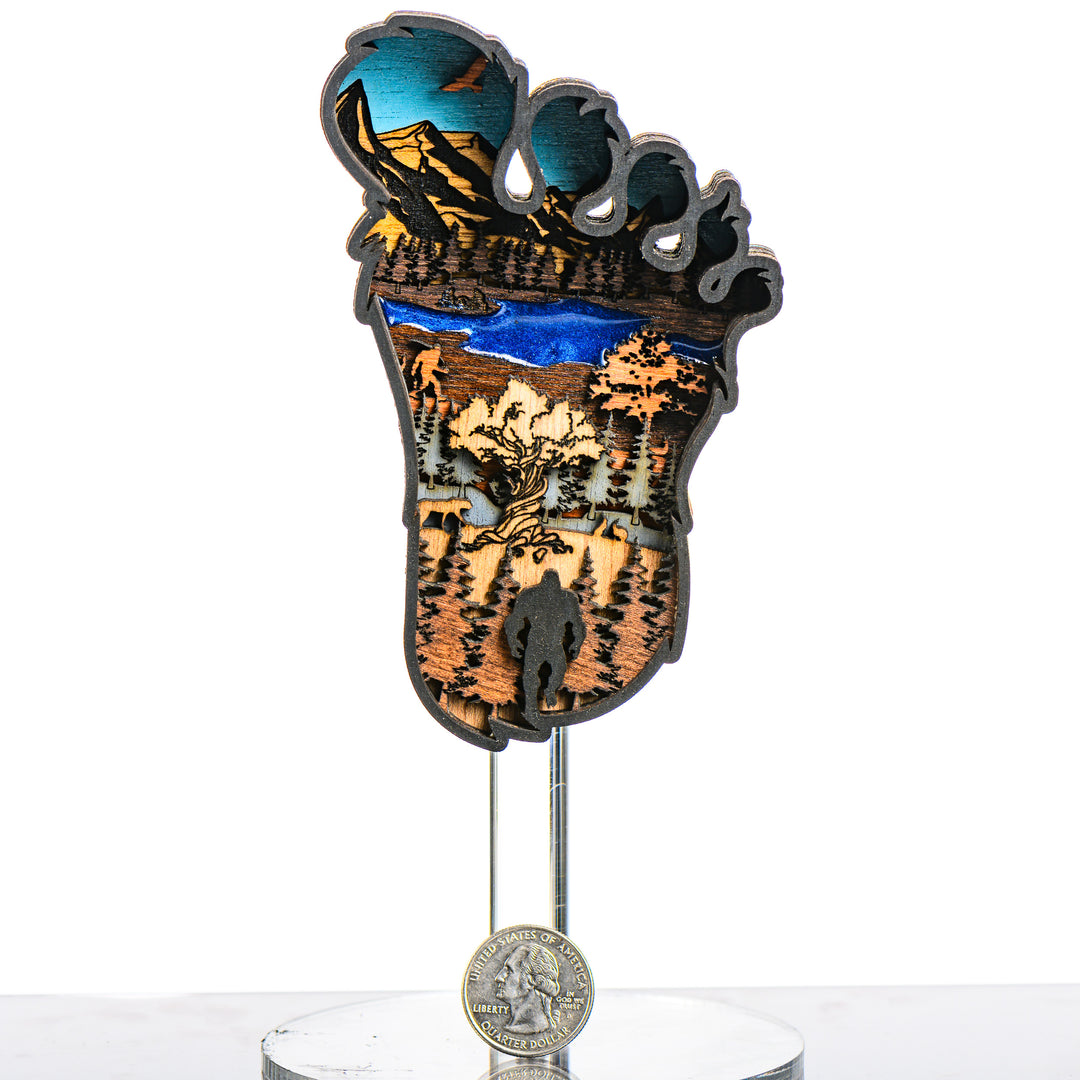 Bigfoot 3D Layered Wood Artmade in Montana by RJS Engraving & Design - laser-cut wood art depicting a wilderness scene inside the silhouette of a Bigfoot foot, Mini with scale
