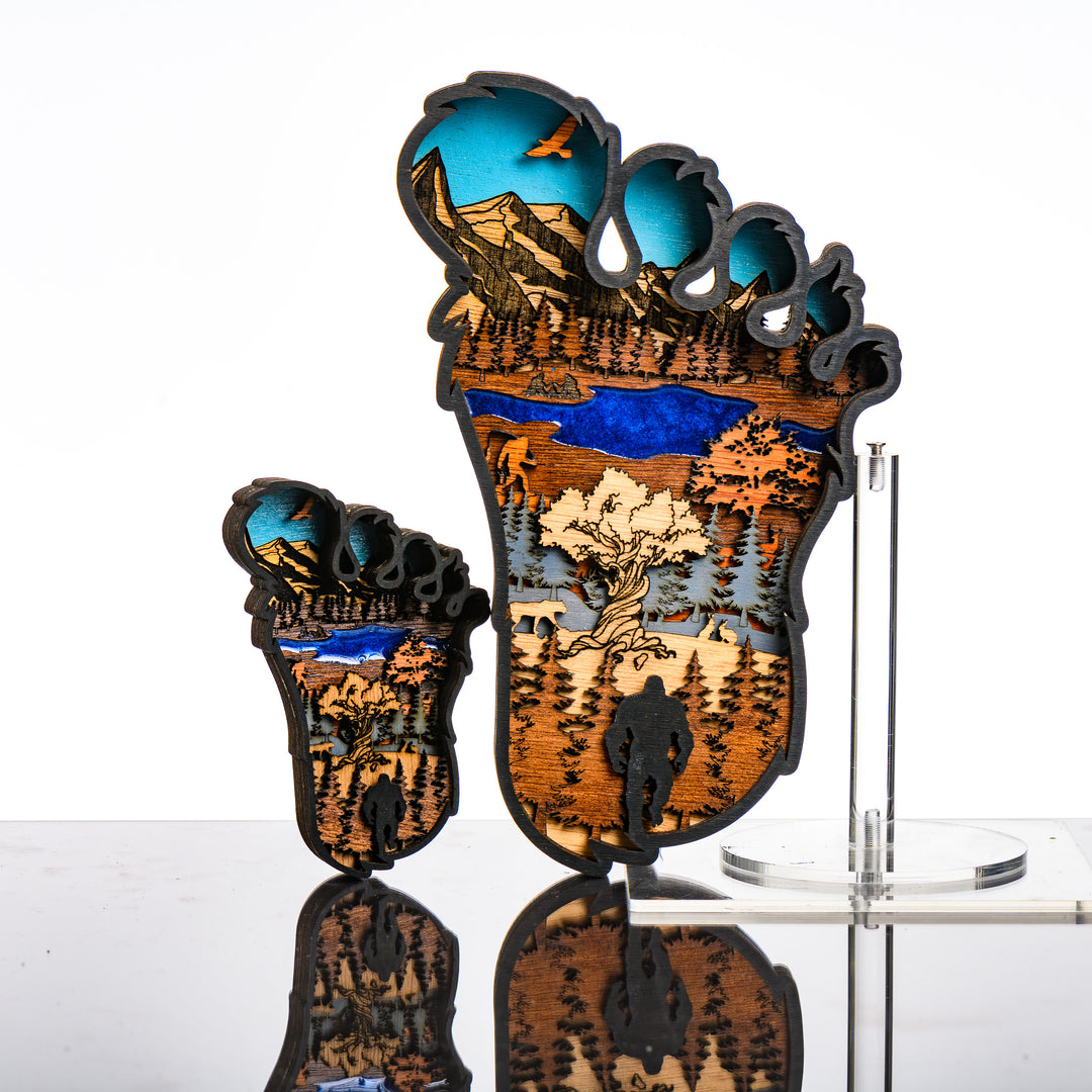 Bigfoot 3D Layered Wood Artmade in Montana by RJS Engraving & Design - laser-cut wood art depicting a wilderness scene inside the silhouette of a Bigfoot foot, multiple sizes