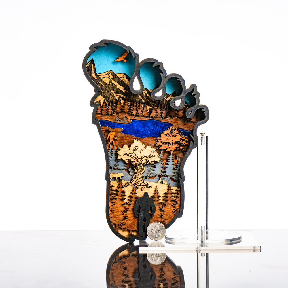 Bigfoot 3D Layered Wood Artmade in Montana by RJS Engraving & Design - laser-cut wood art depicting a wilderness scene inside the silhouette of a Bigfoot foot, Standard