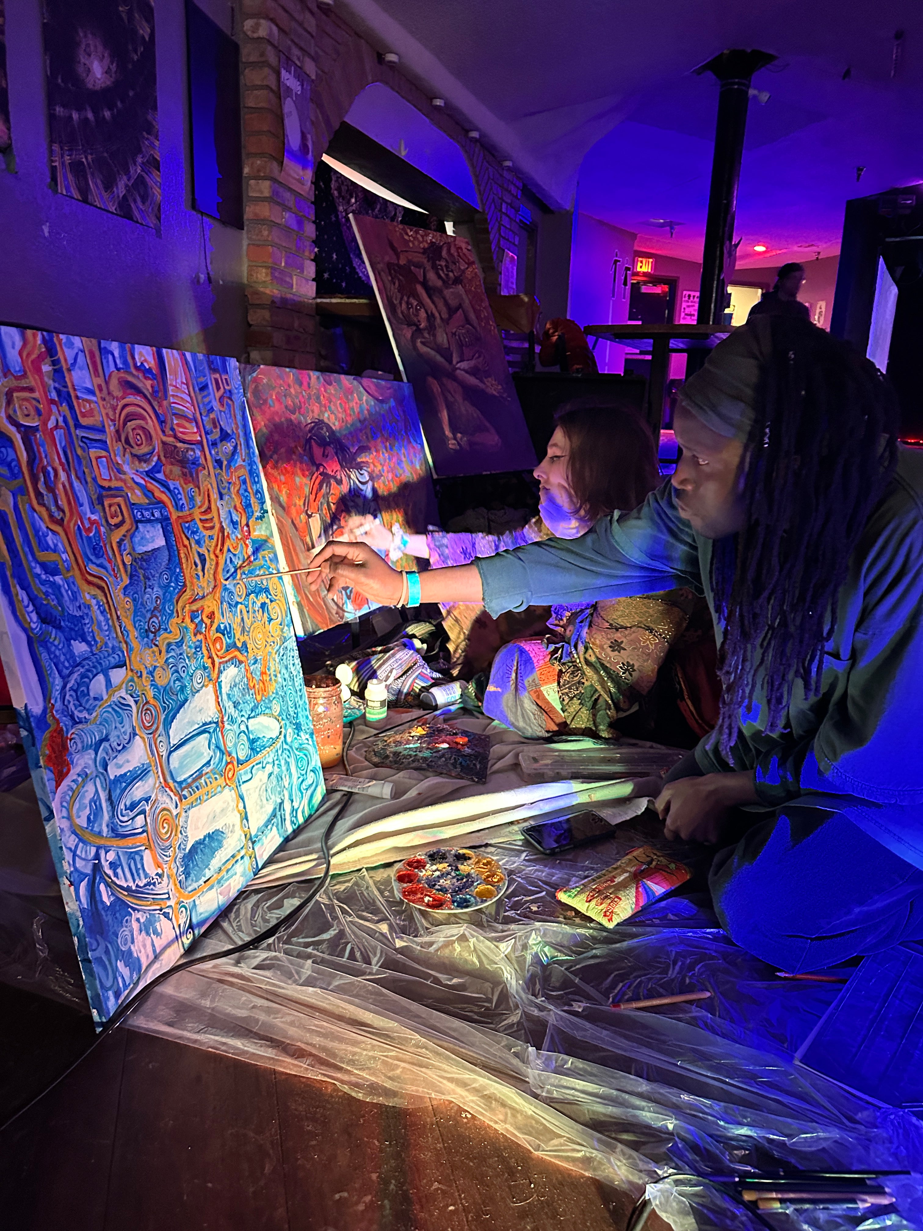 Photograph of two people live painting at a Starlight Reunion event