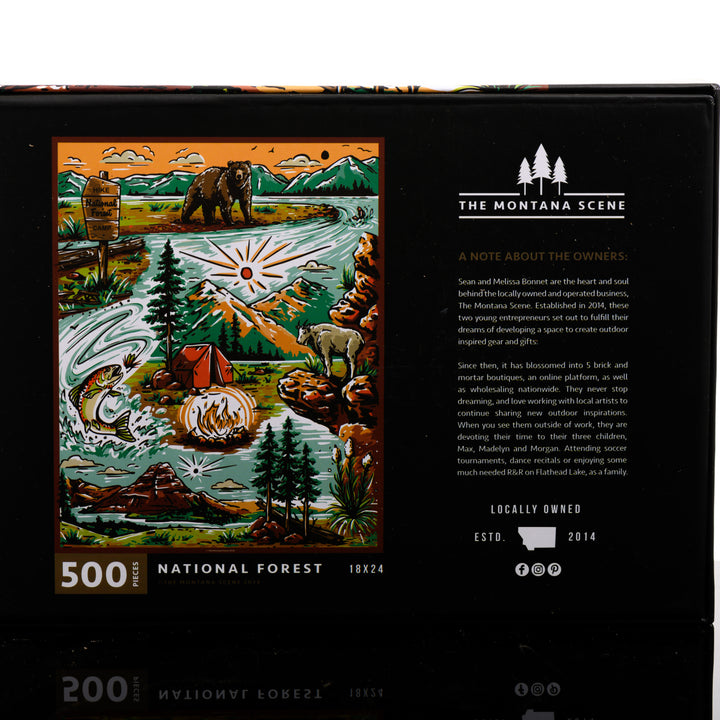 Hand drawn, Montana-made 500 piece puzzle by the Montana Scene--named National Forest-- featuring a bear, national forest sign, fly fishing, tent and mountain goat; image depicts the back of the puzzle box.