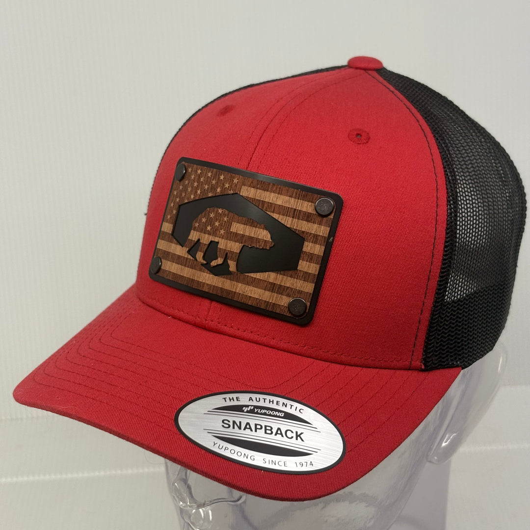 Red and black snapback cap with wooden patch on a white background