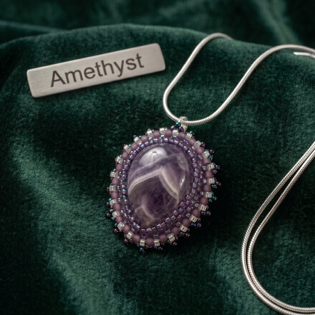 A hand beaded amythest pendant with a silver chain and purple and silver beads