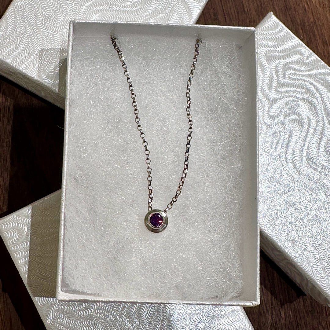 A February birthstone silver necklace in a white gift box