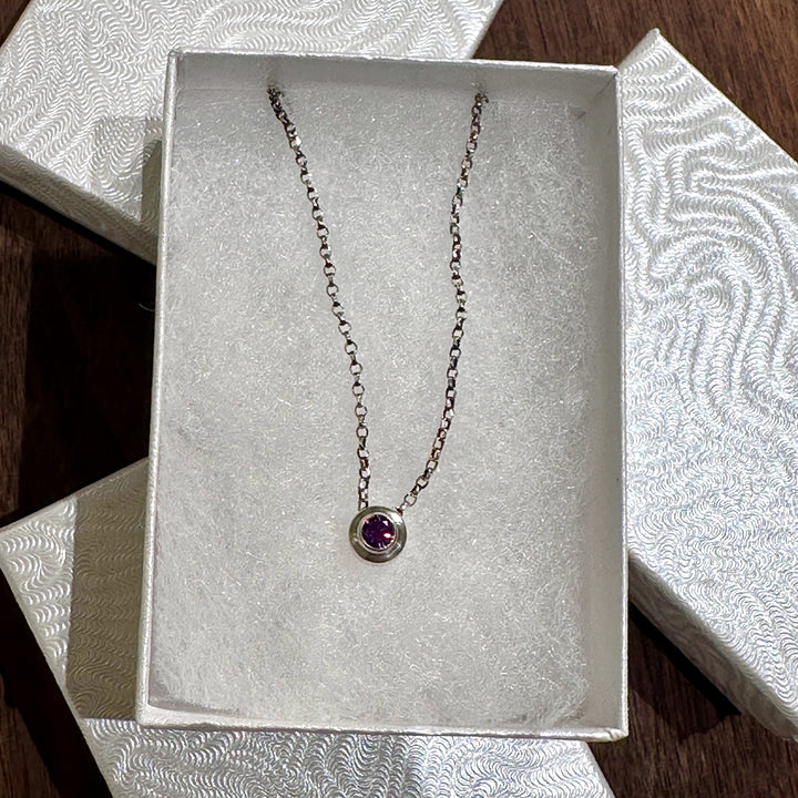 A February birthstone silver necklace in a white gift box