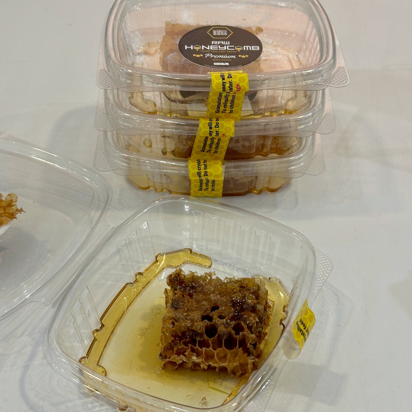 Stacked containers of gourmet Montana honeycomb and one open package. 
