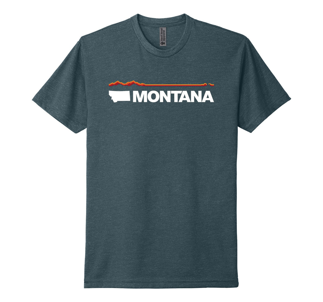 Indigo blue Next Level Apparel unisex adult tee featuring elements of the official MT Department of Commerce ‘Montana Brand’—the solid shape of the state and ‘Montana’ lettering—plus a red and orange line representing Montana’s geography (mountains in the west/ left to plains in the east/ right), made in Montana by Blue Peak Creative