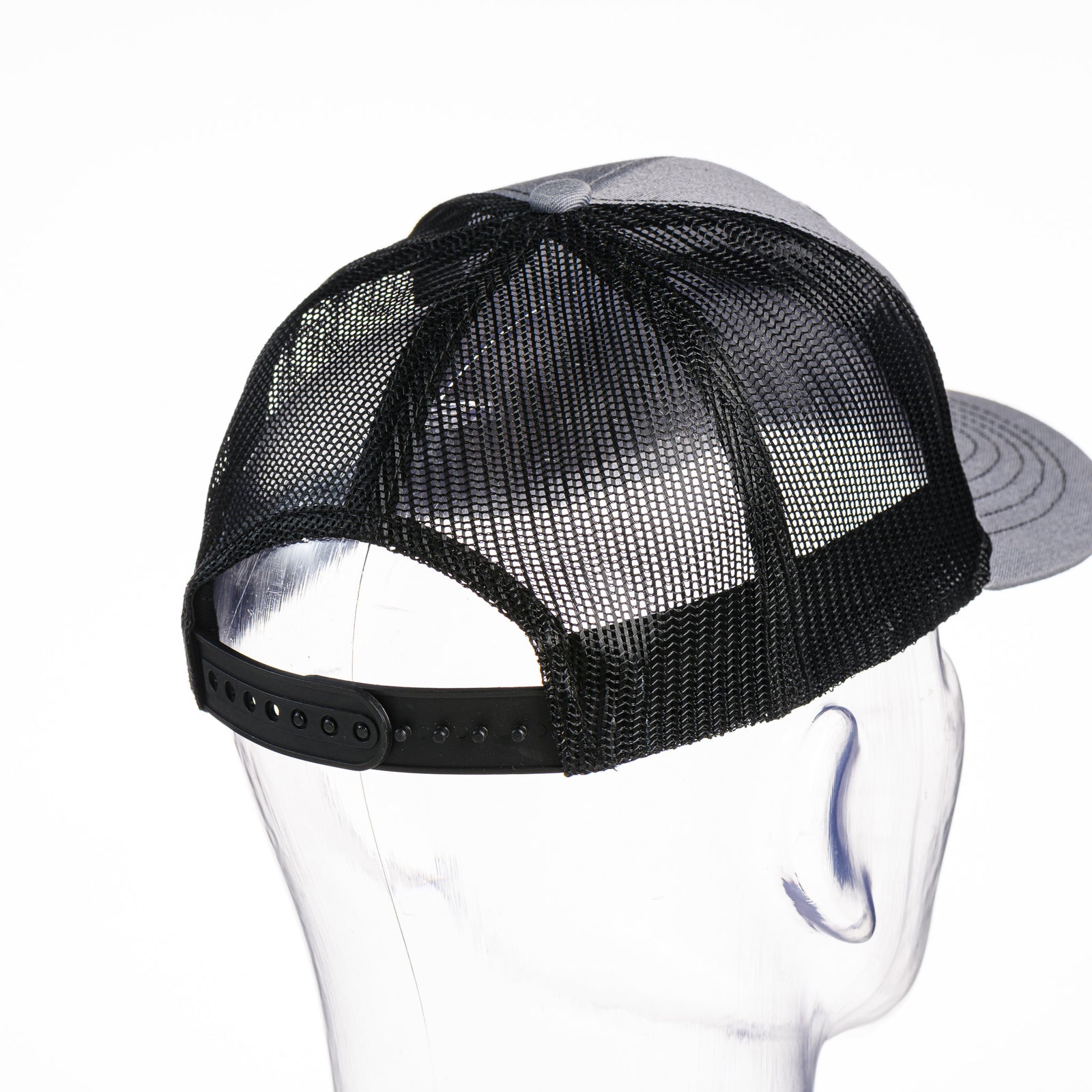 Back of a grey and black Cats Montana Youth Snapback Trucker Hat made in Montana (home of the MSU Cats) by Blue Peak Creative—a grey and black youth trucker hat embroidered with a white Cats script over a blue Montana state silhouette, outlined in white