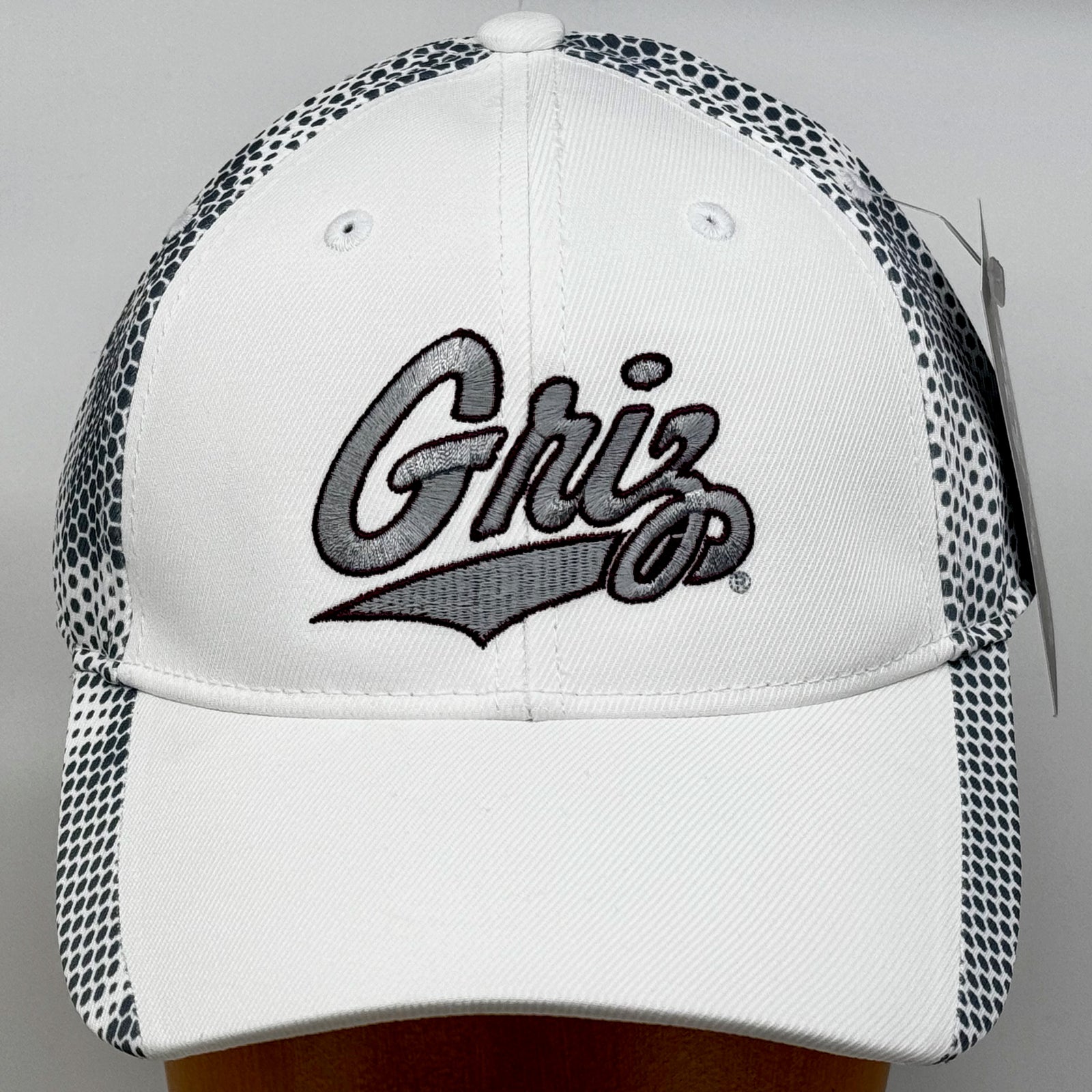 Front view of a white and grey Outlined Griz Script - Camo Hex Hat made in Missoula, MT (home of the UM Grizzlies) by Blue Peak Creative—a camouflage white and grey hat embroidered with the silver University of Montana Griz script outlined in maroon