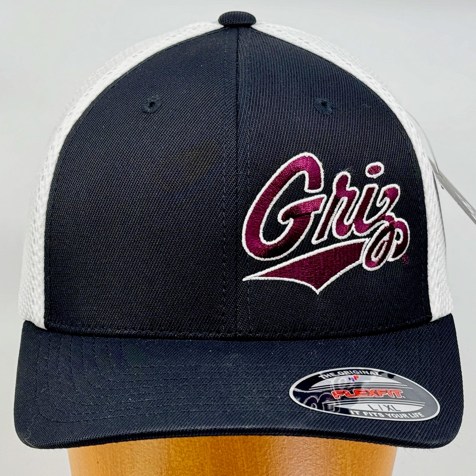 Black and white Outlined Griz Script - Ultrafibre and Airmesh Flexfit Hat made in Missoula, MT (home of the UM Grizzlies) by Blue Peak Creative—a black and white Ultrafibre and Airmesh Flexfit Hat embroidered with the Outlined Griz Script in maroon and white (front)