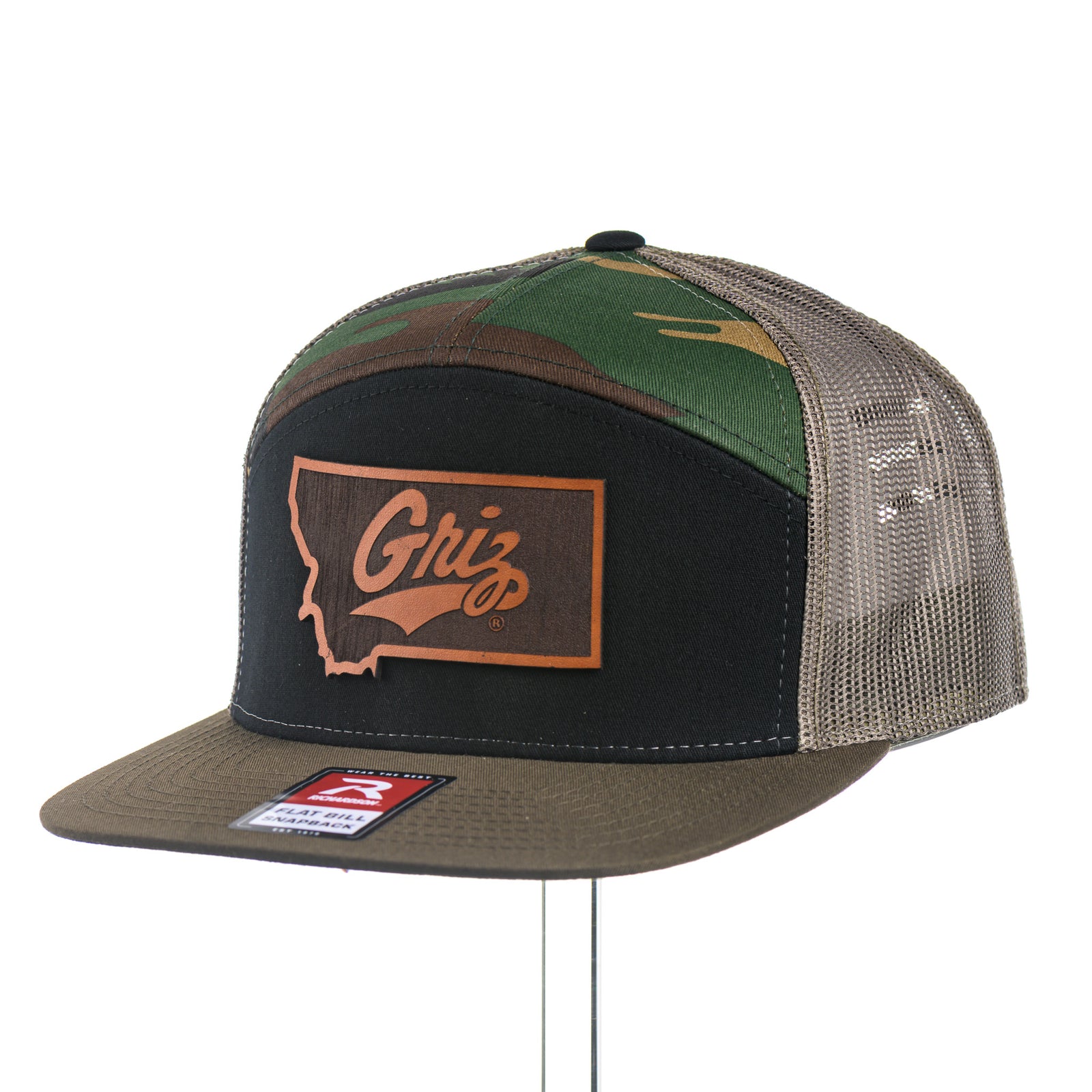 Camouflage and black trucker hat with  University of Montana Griz logo leather patch on a white background