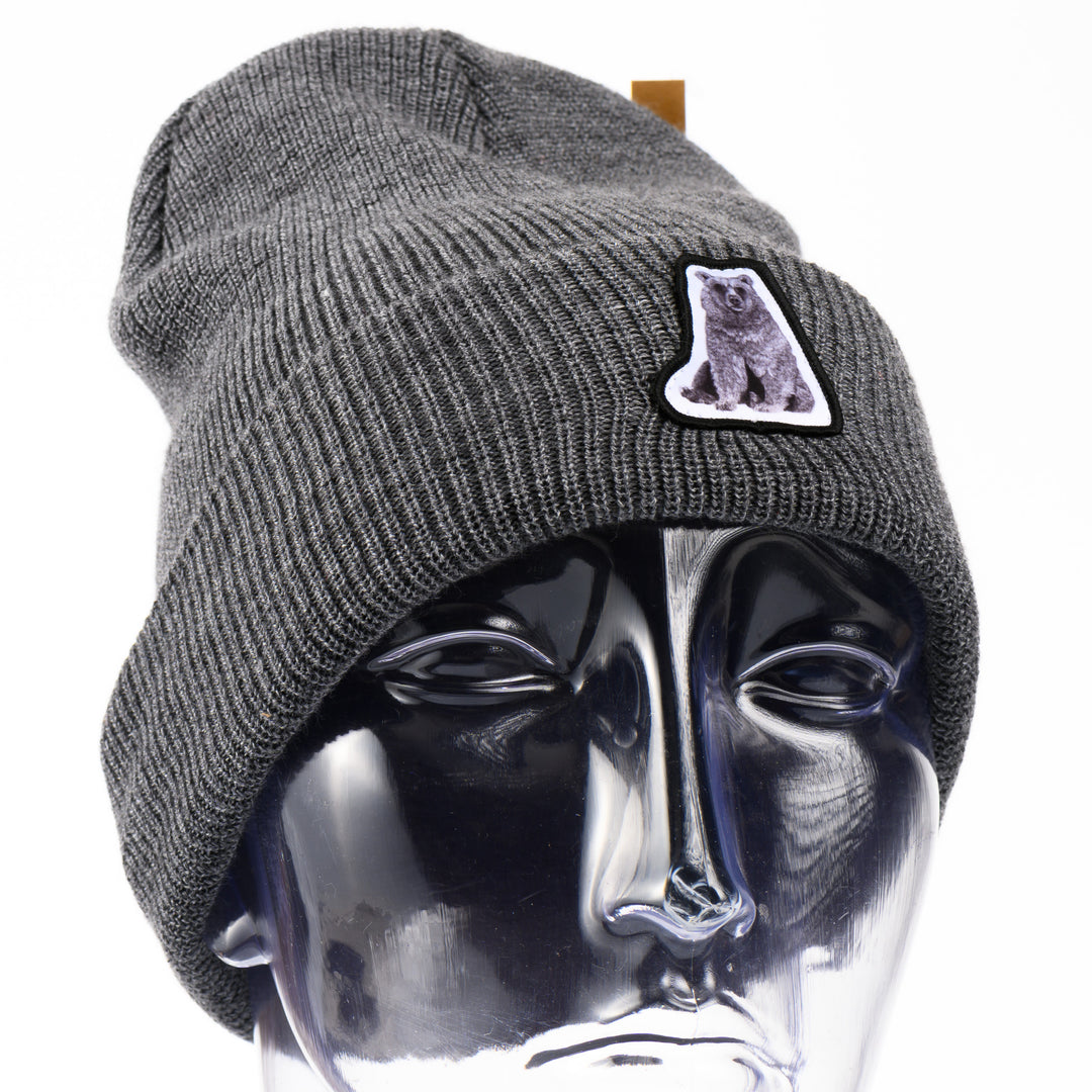 Gray beanie with a hand drawn bear patch on a mannequin head against a white background