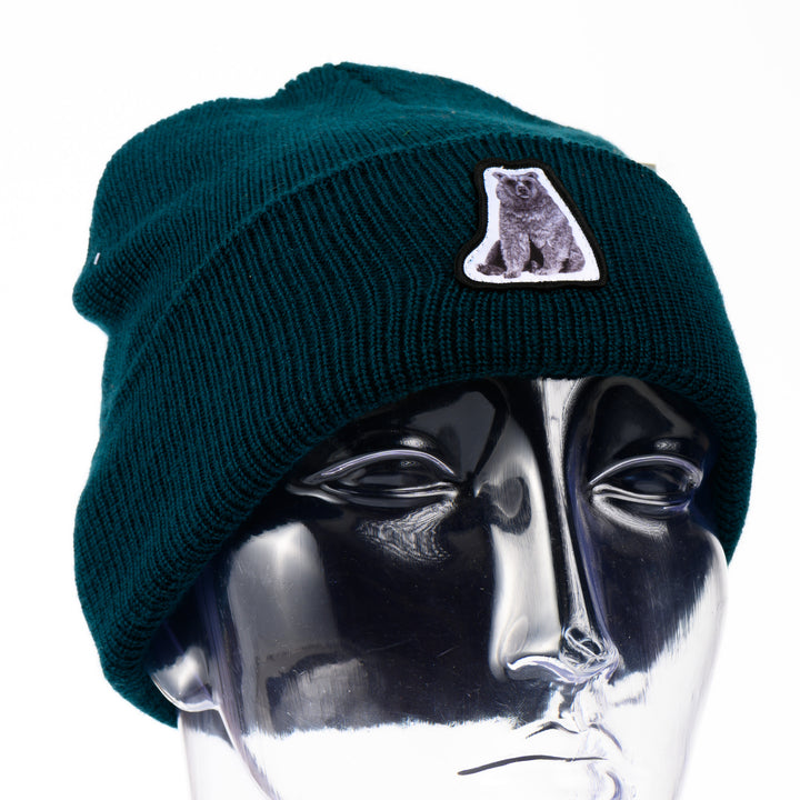 Dark teal beanie with a bear patch on a mannequin head against a white background
