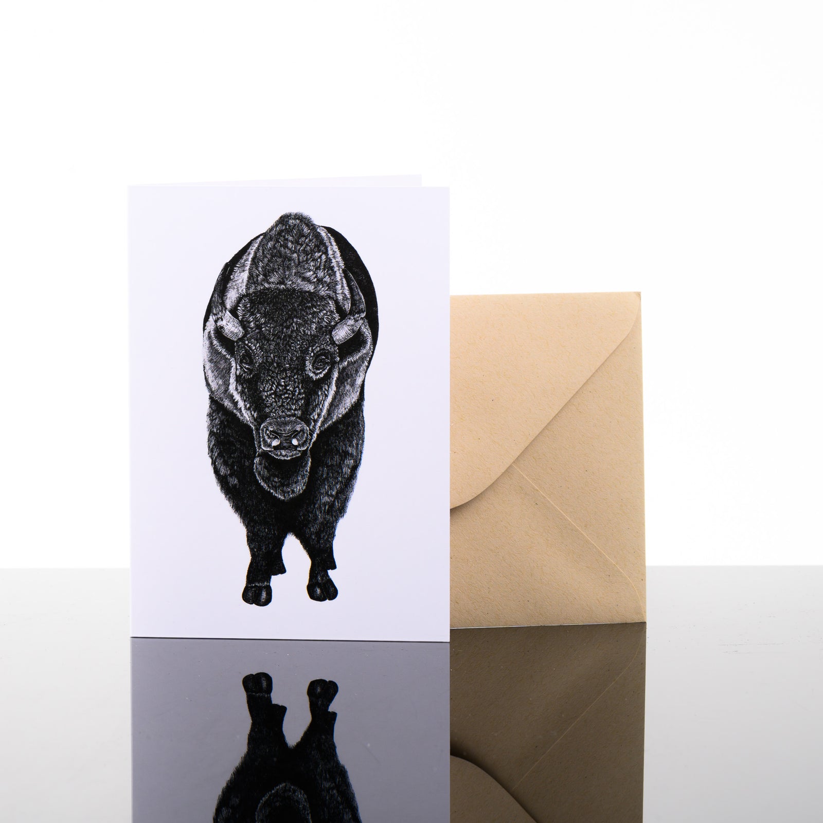 Blank greeting card featuring original black and white artwork by Brittany Finch - a bison, facing front - and kraft brown envelope by Brittany Finch Art in Montana