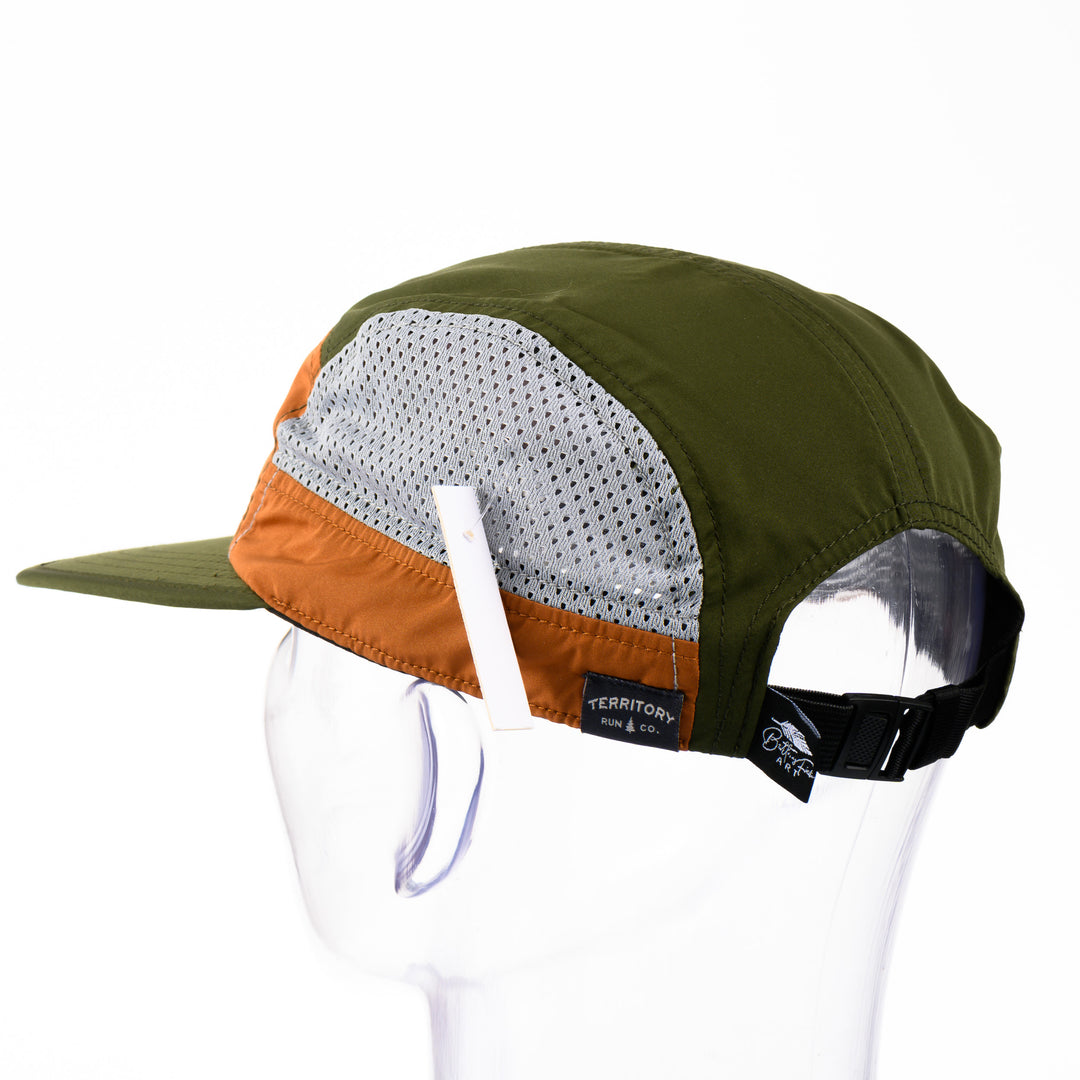 Back of a green and orange adjustable mesh-sided cap with a patch featuring original black and white artwork by Brittany Finch -  a soaring red tailed hawk, wings outstretched -  made in Montana by Brittany Finch Art and displayed on a mannequin head 