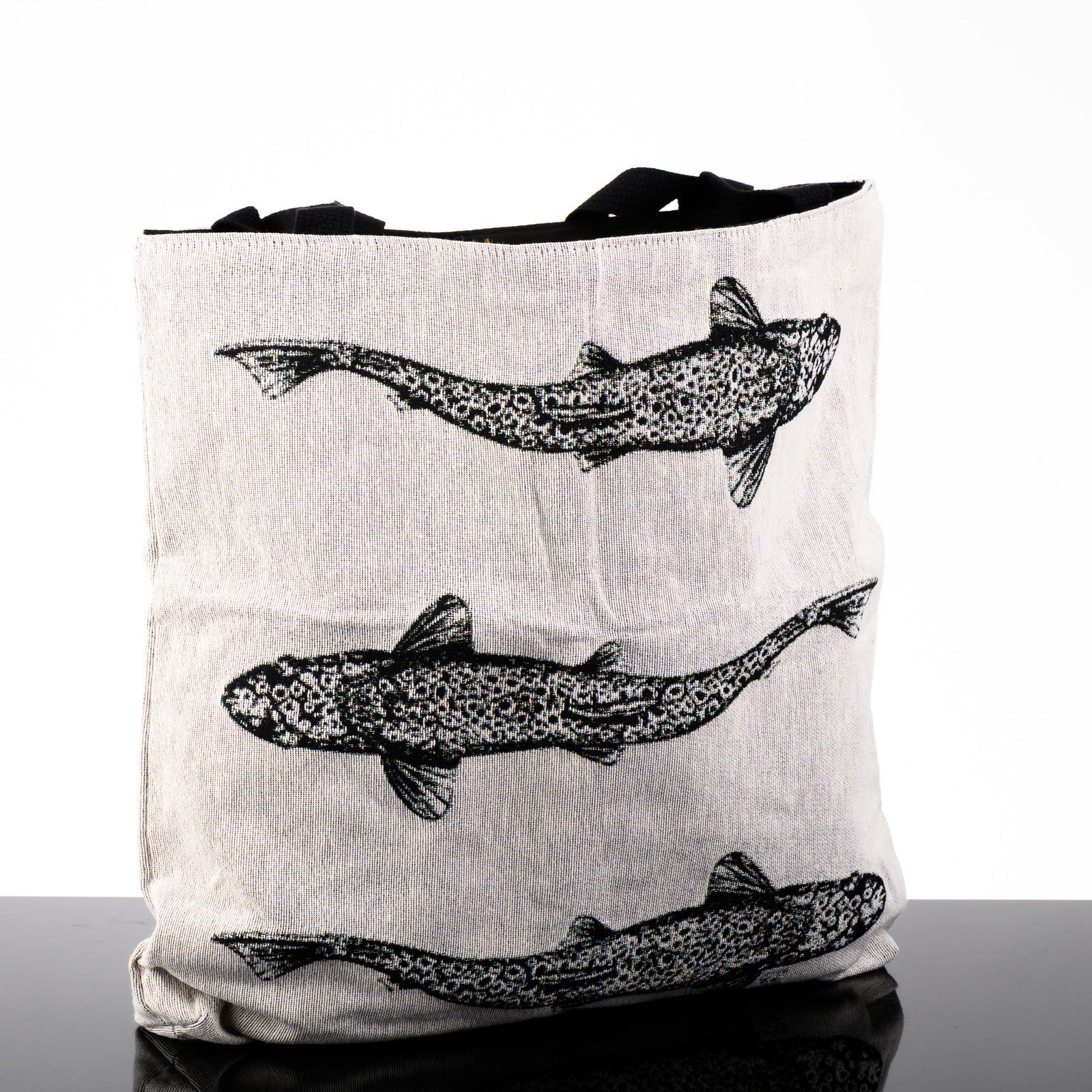 White woven tote bag featuring original black and white artwork by Brittany Finch - three swimming brown trout viewed from above -  made in Montana by Brittany Finch Art