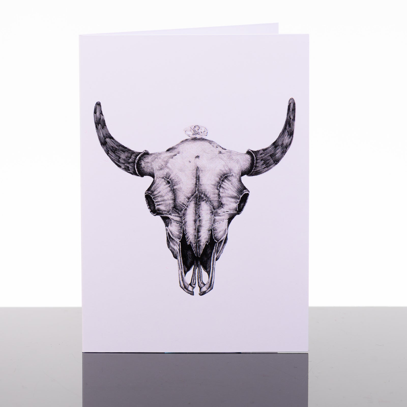 Blank greeting card featuring original black and white artwork by Brittany Finch - a petite black-tailed prairie dog skull centered on a robust bison skull - made in Montana by Brittany Finch Art