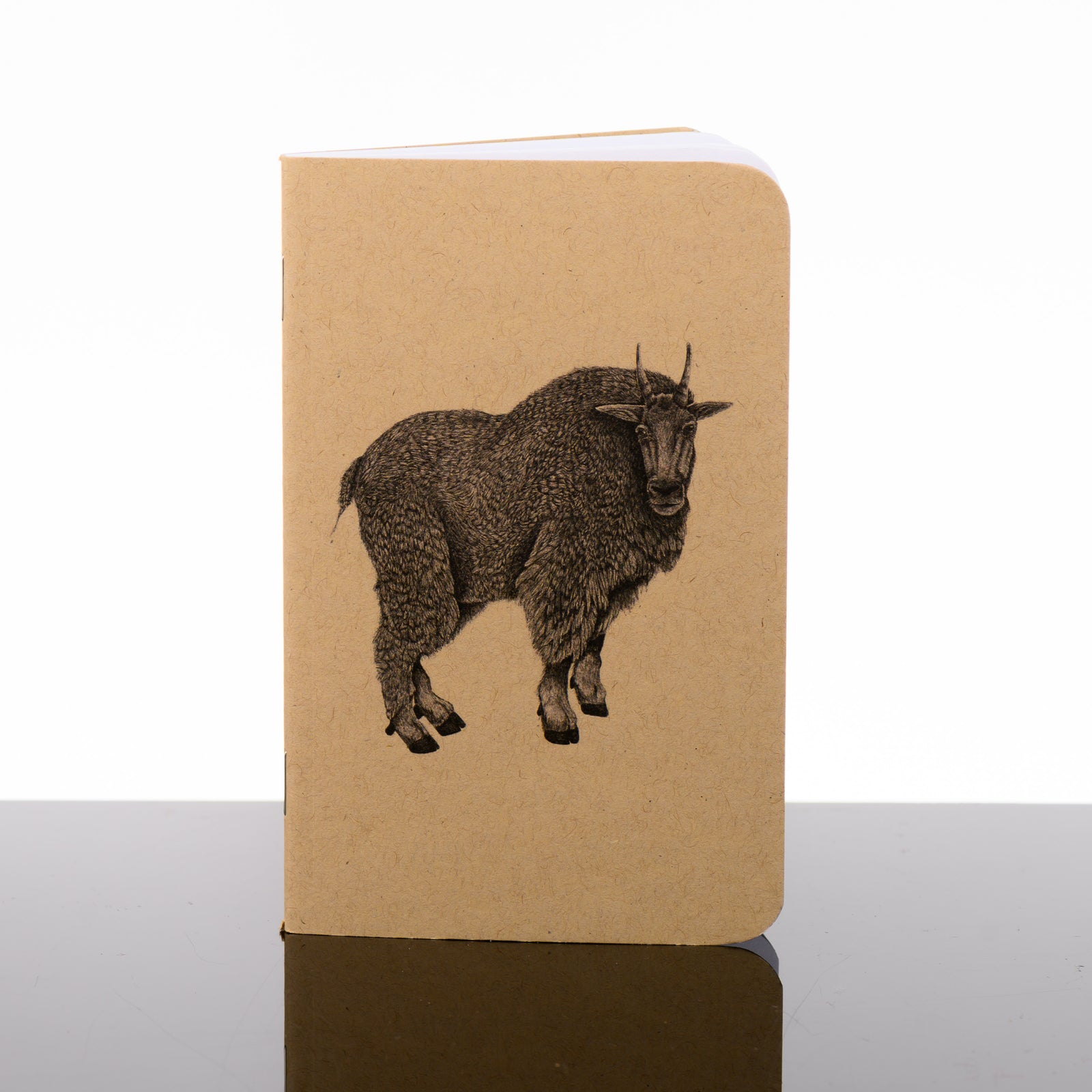 Pocket journal with a brown Kraft cover featuring original black and white artwork by Brittany Finch - a mountain goat facing the viewer - handmade by Brittany Finch Art in Montana