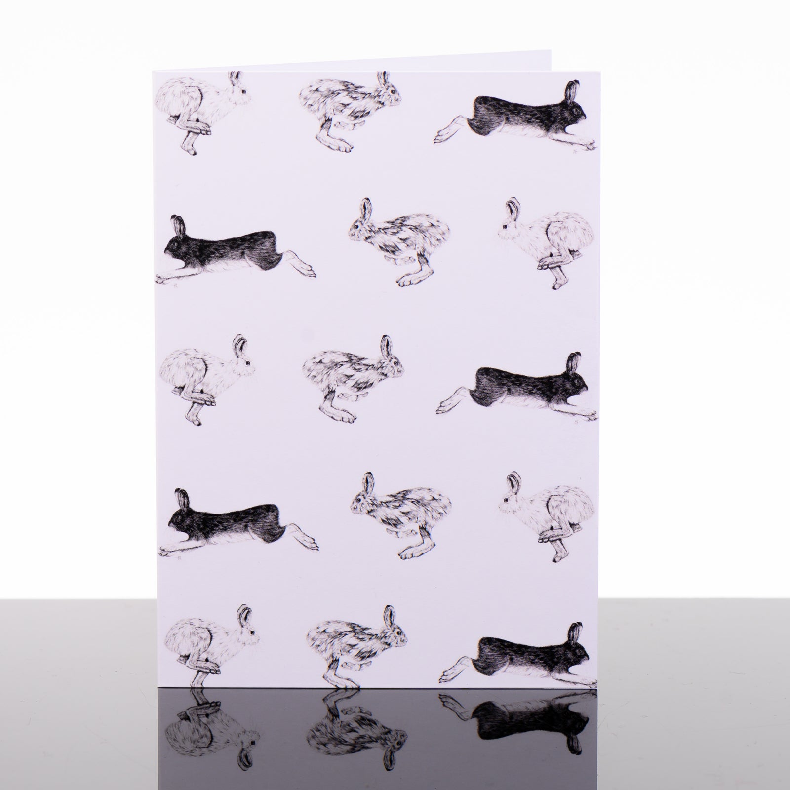 Blank greeting card featuring original black and white artwork by Brittany Finch - rows of racing hares in alternating directions - made in Montana by Brittany Finch Art