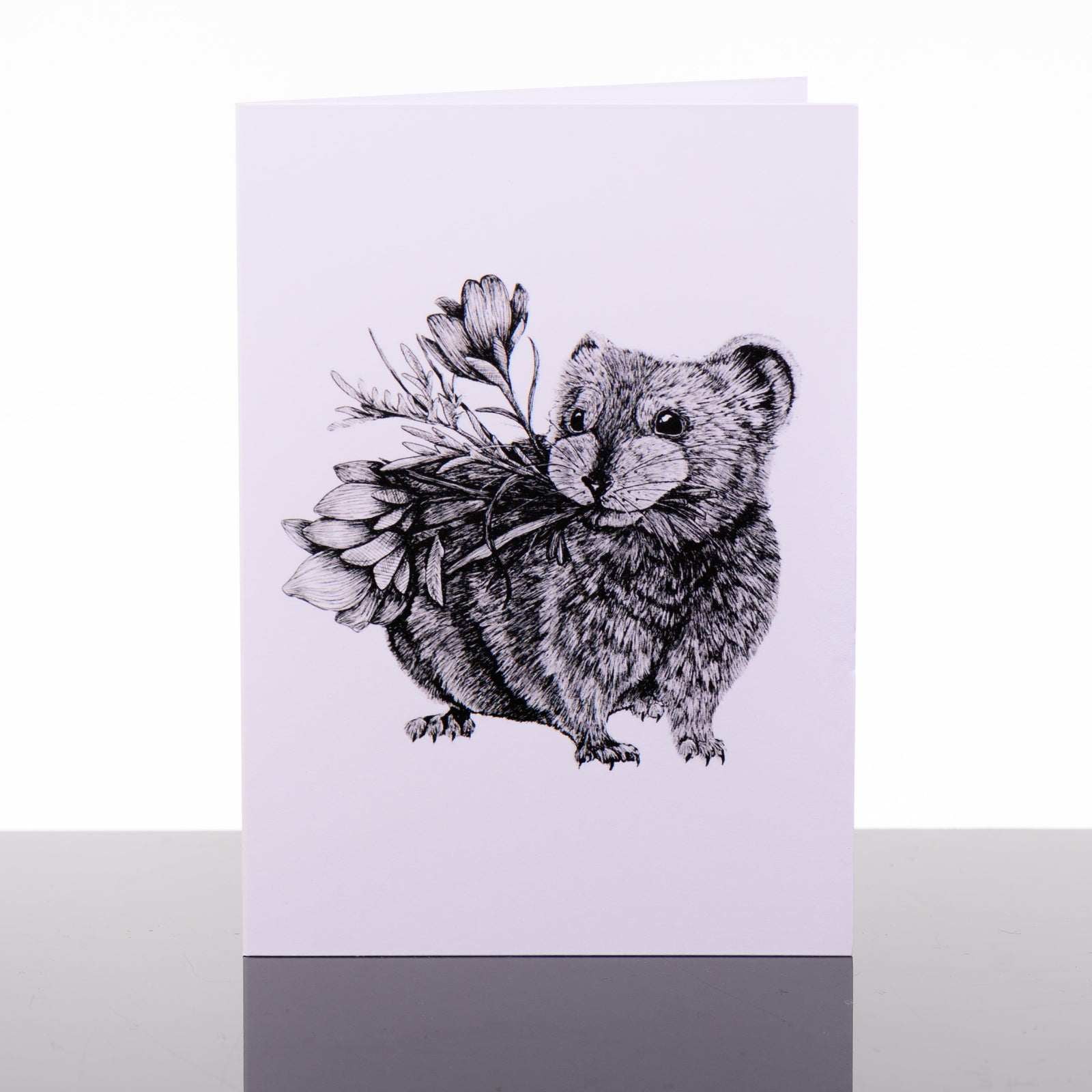 Blank greeting card featuring original black and white artwork by Brittany Finch - an adorable pika carrying flowers in its mouth - made in Montana by Brittany Finch Art