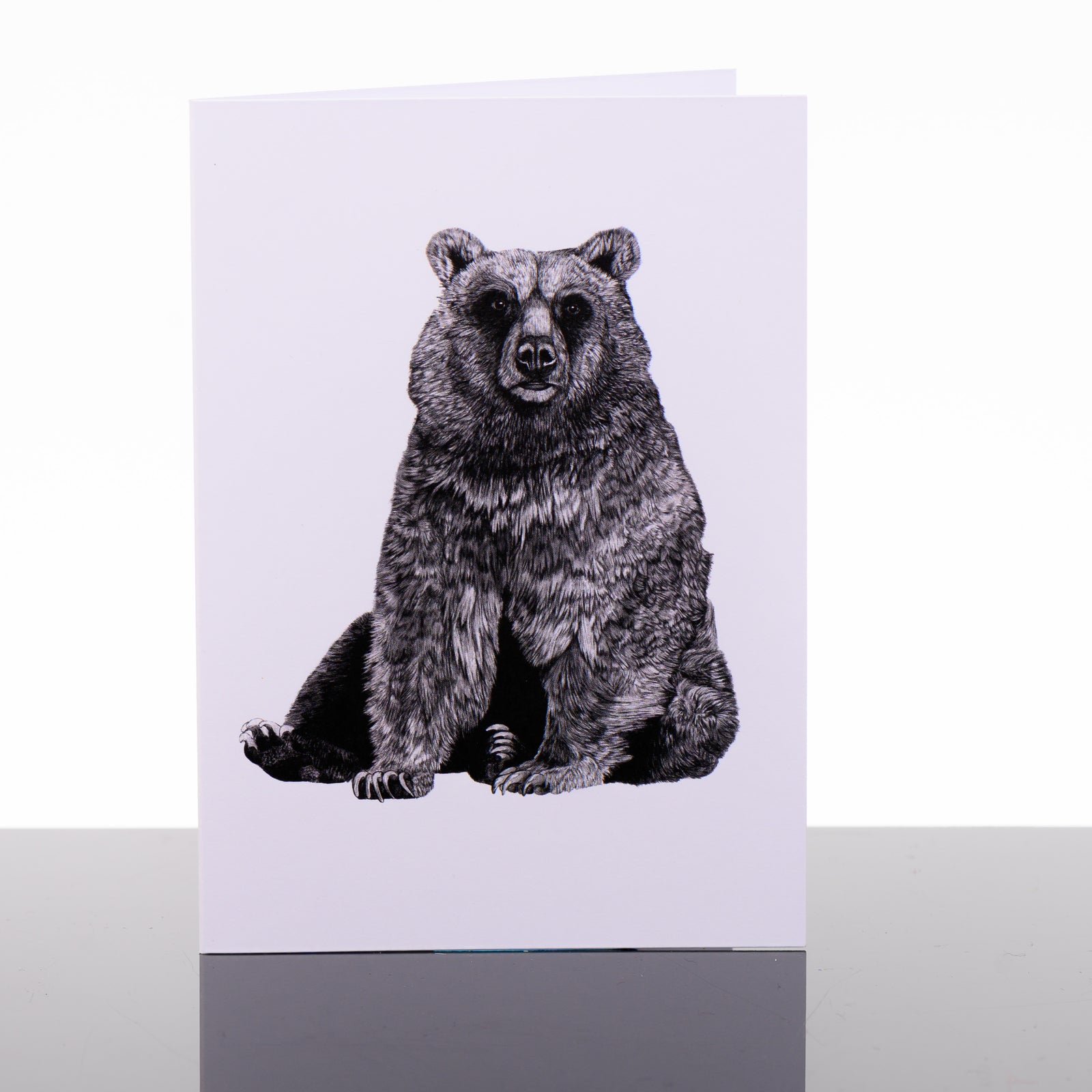 Blank greeting card featuring original black and white artwork by Brittany Finch - a serene bear, sitting on its haunches - by Brittany Finch Art in Montana